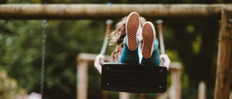 Photo of child on swing in play park